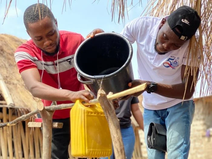 Two people working together to collect clean water.